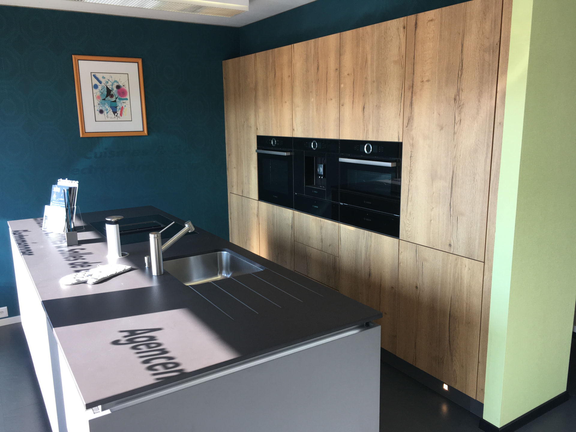 Exposition : îlot gris anthracite face aux colonnes en bois clair